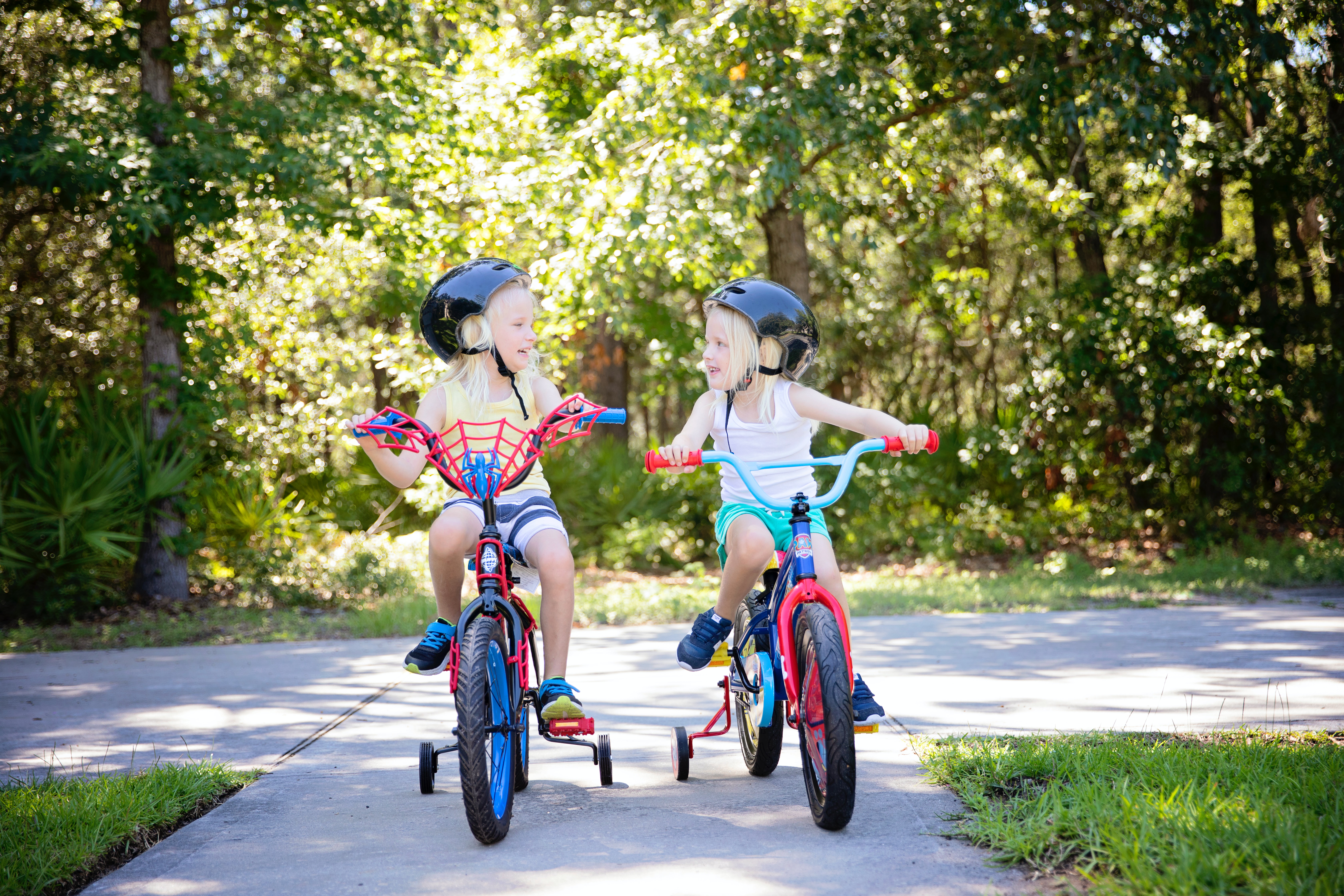 Churchich Recreation Keeping Kids Busy this Summer Without Electronics Two Kids on Bikes with Training Wheels Smiling at each other