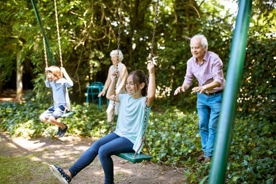 Grandparents swinging grandchildren on a swingset