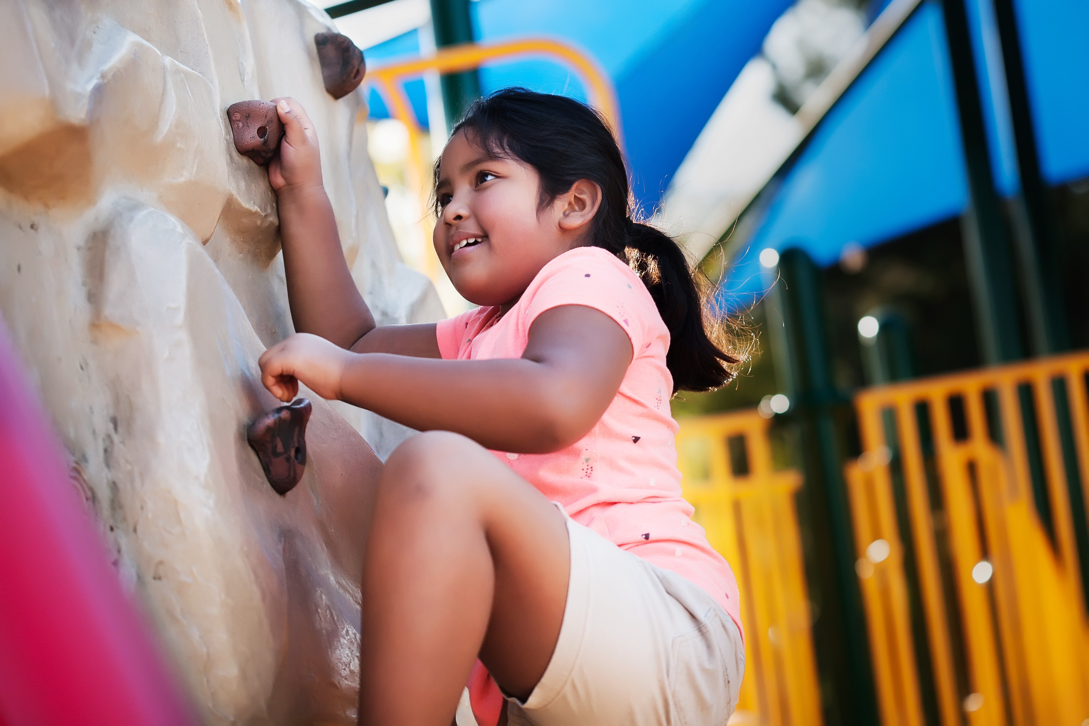Young girl climbing rock wall