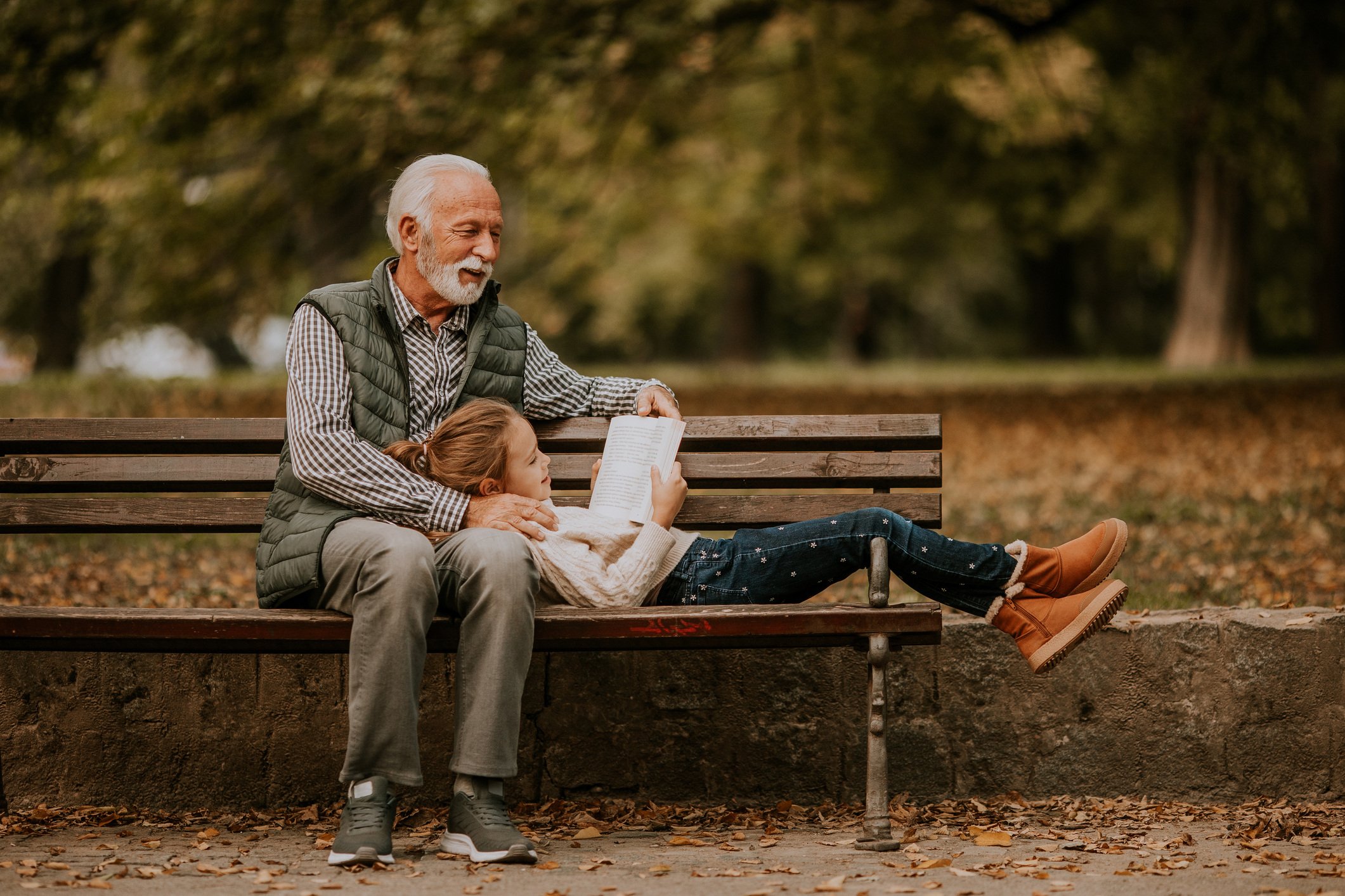 Grandfather spending time with his granddaughter on bench